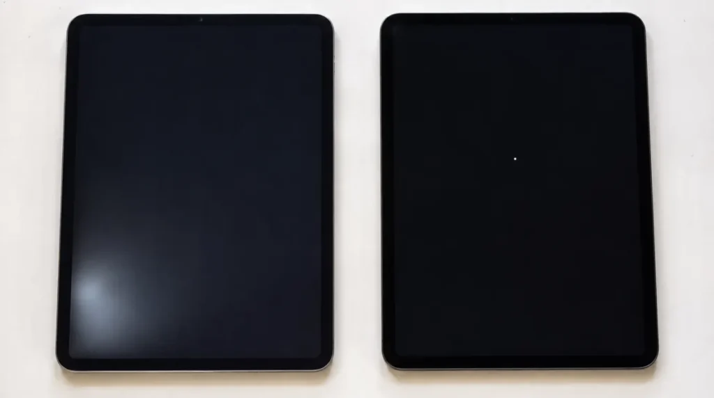 Two iPads showing LCD backlight bleed vs OLED stuck pixel on dark screen